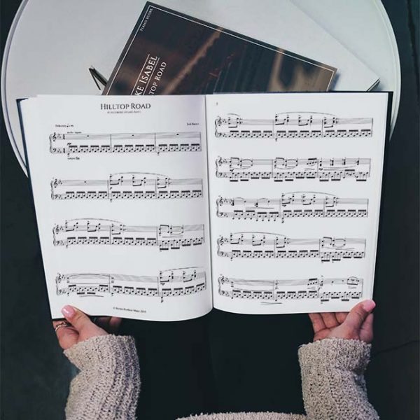 hilltop road sheet music held by a woman in a grey sweater